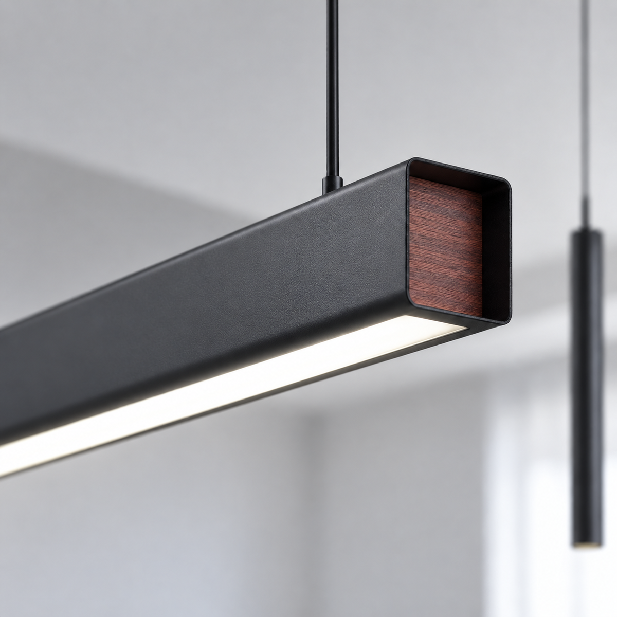 Close-up of the black pendant's recessed wood end insert, fine aluminium finish and illuminated underside diffuser