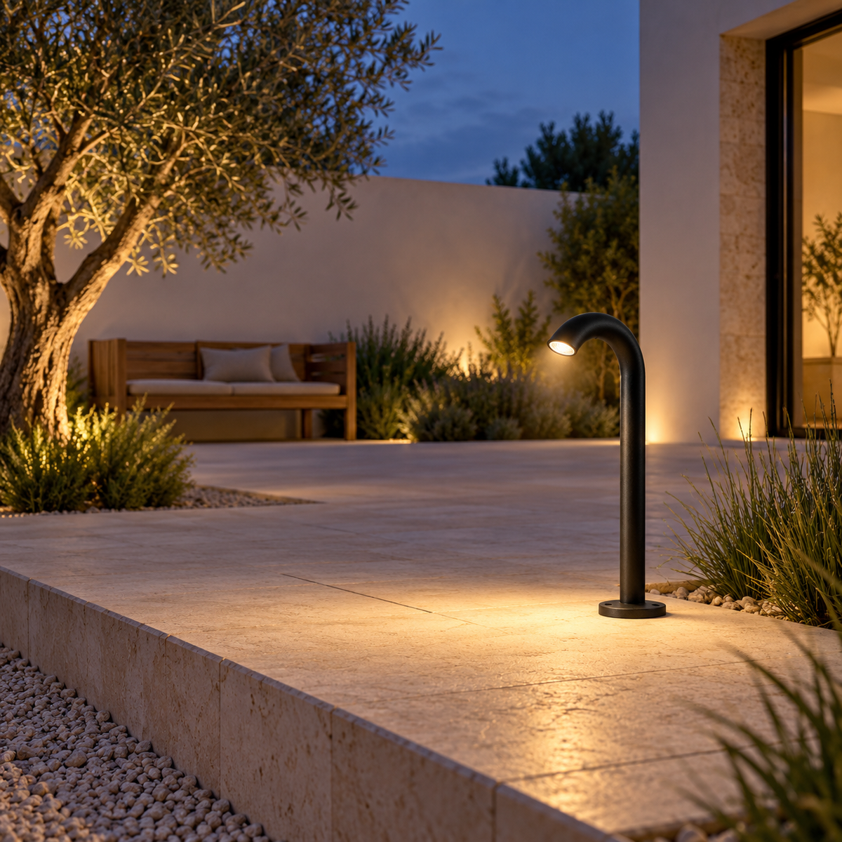Curved black garden path light installed beside a limestone courtyard terrace