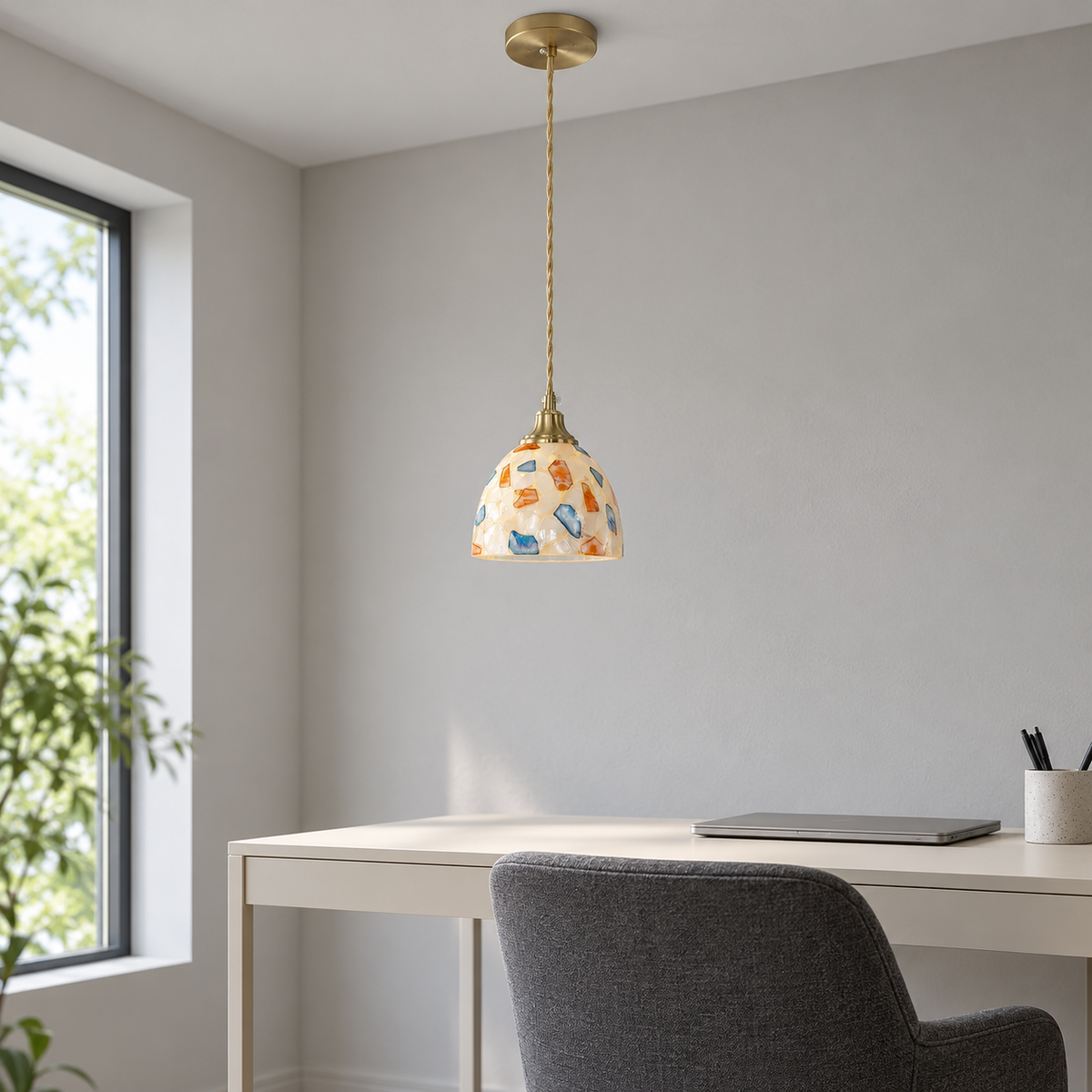 Small multicolour shell and glass dome pendant installed above a desk in neutral daylight