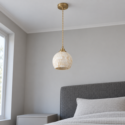 Ivory shell mosaic globe pendant seen from below in a neutral daylight bedroom
