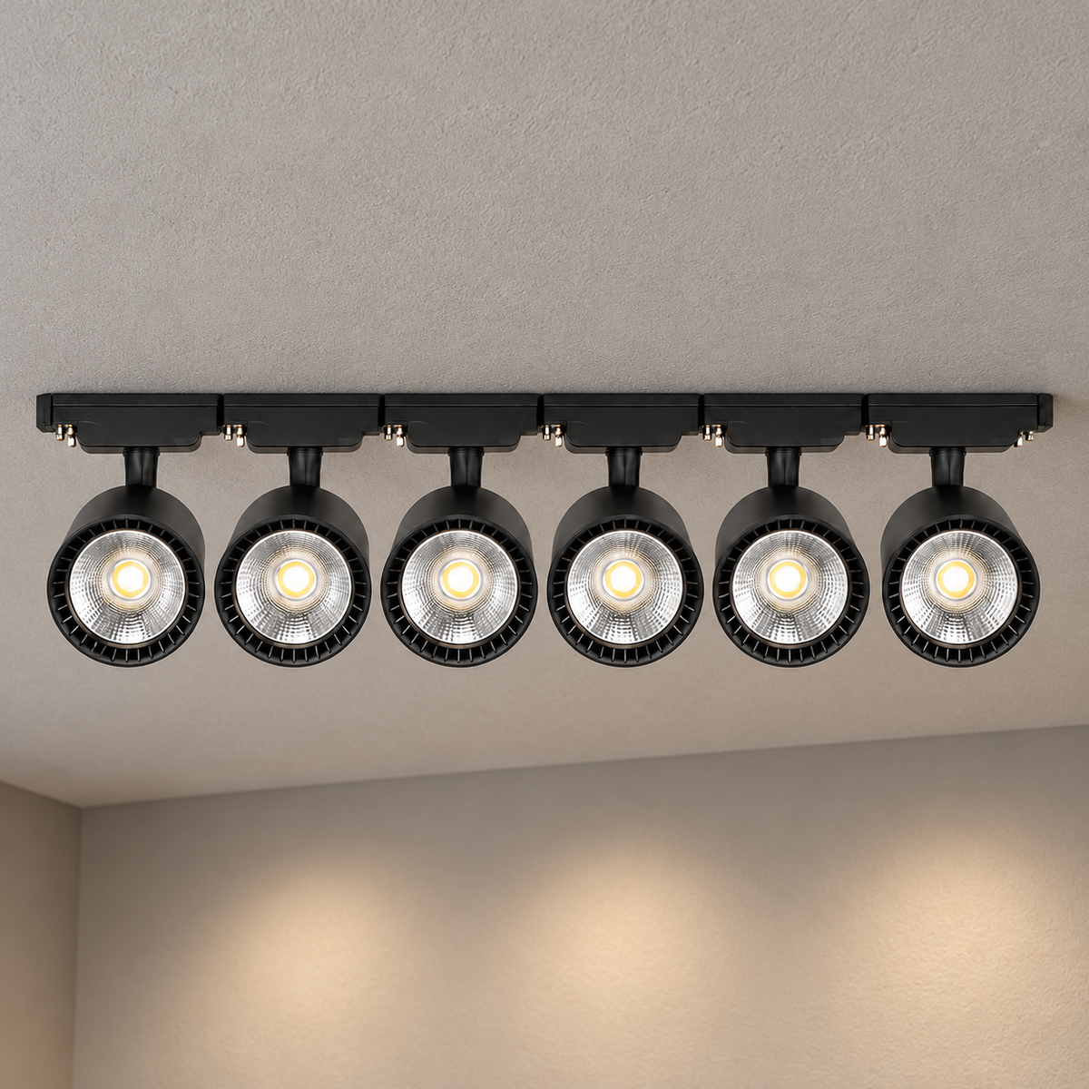 Black six-head LED track lighting kit, 30W configuration, illuminated and installed against a textured ceiling with visible room context.