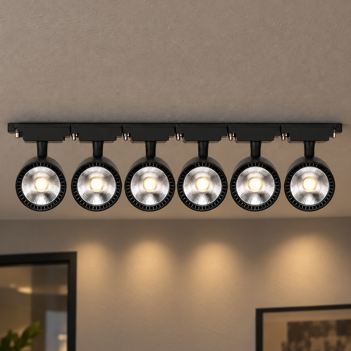 Black six-head LED track lighting kit, 40W configuration, illuminated and installed against a textured ceiling with visible room context.