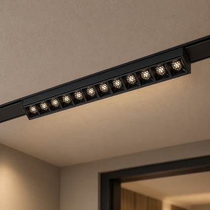 Magnetic fixed grille light 12W, black finish, with twelve illuminated recessed honeycomb optics, installed in a ceiling track.
