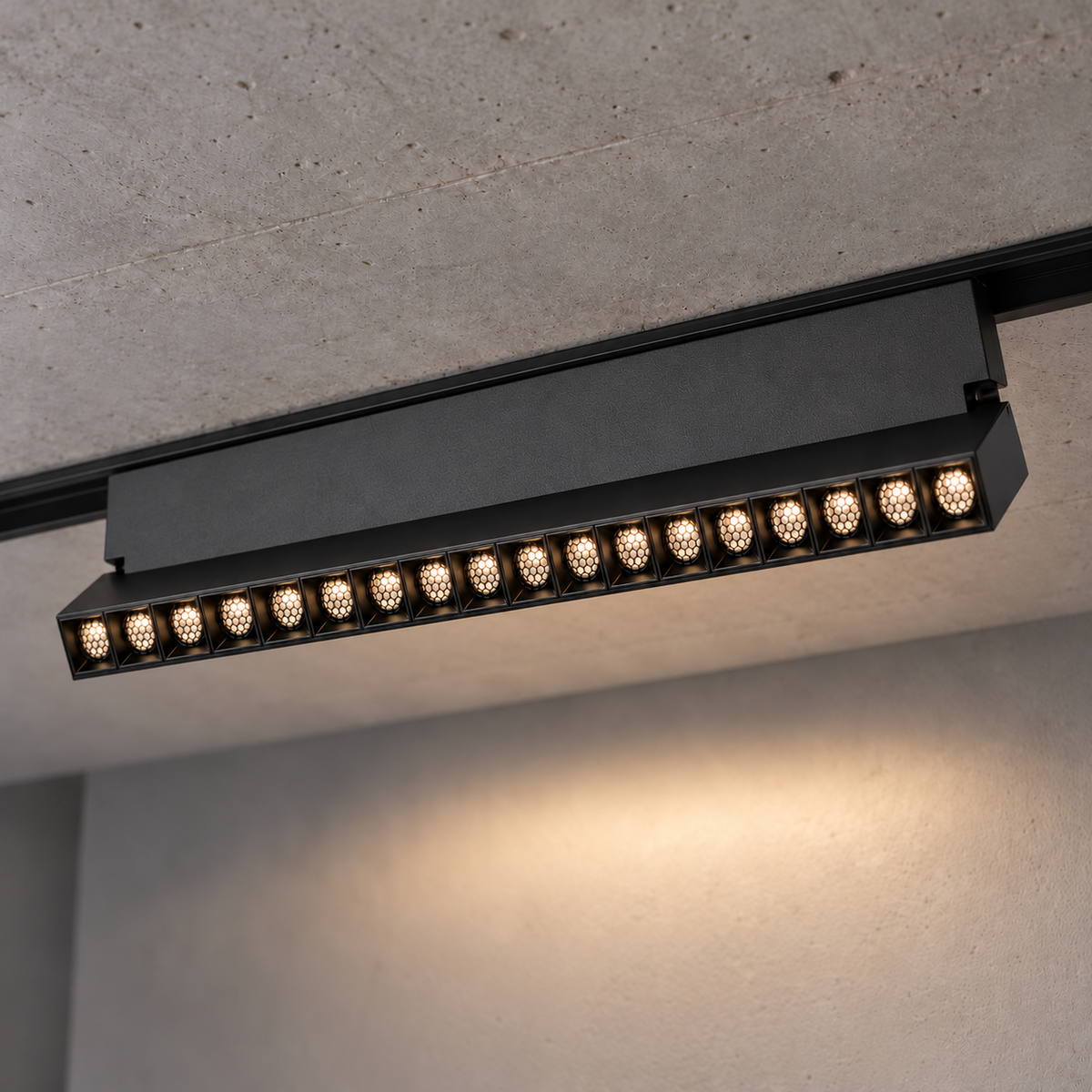 Magnetic folding grille light 18W, black finish, with eighteen illuminated recessed honeycomb optics and visible hinge support, installed in a ceiling track.