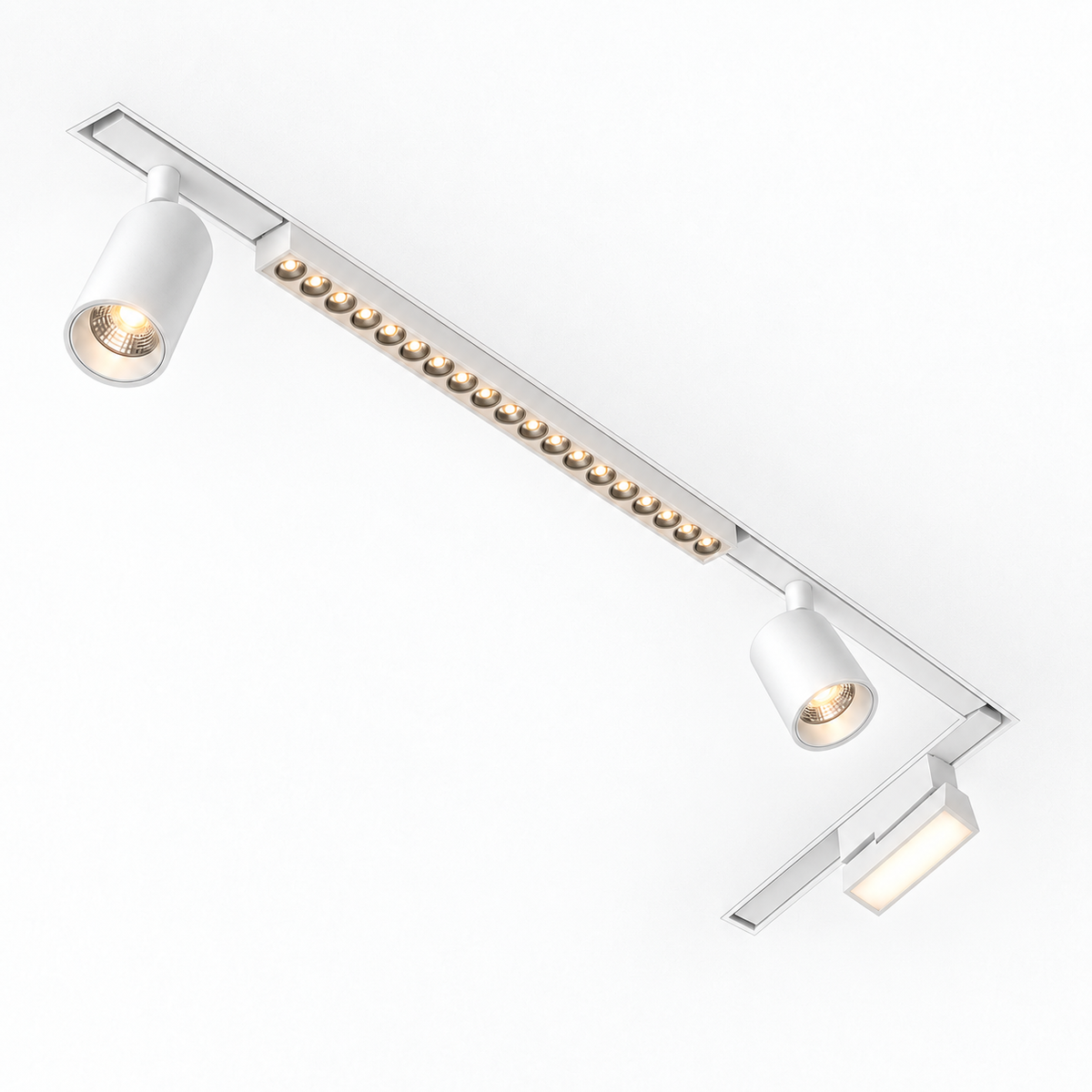 White slim magnetic track lighting installed in an L-shaped recessed ceiling layout, with warm-lit spotlights, grille and folding floodlight; example configuration.